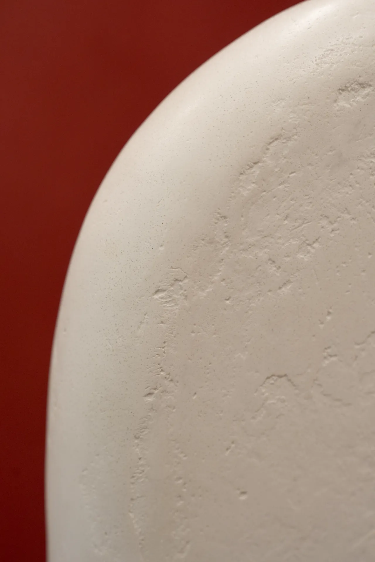 Forme organique en béton ciré blanc sur fond terracotta
