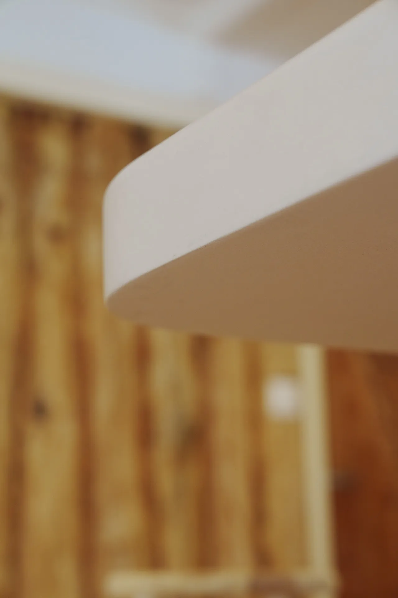 Détail arrondi béton ciré sur fond bois