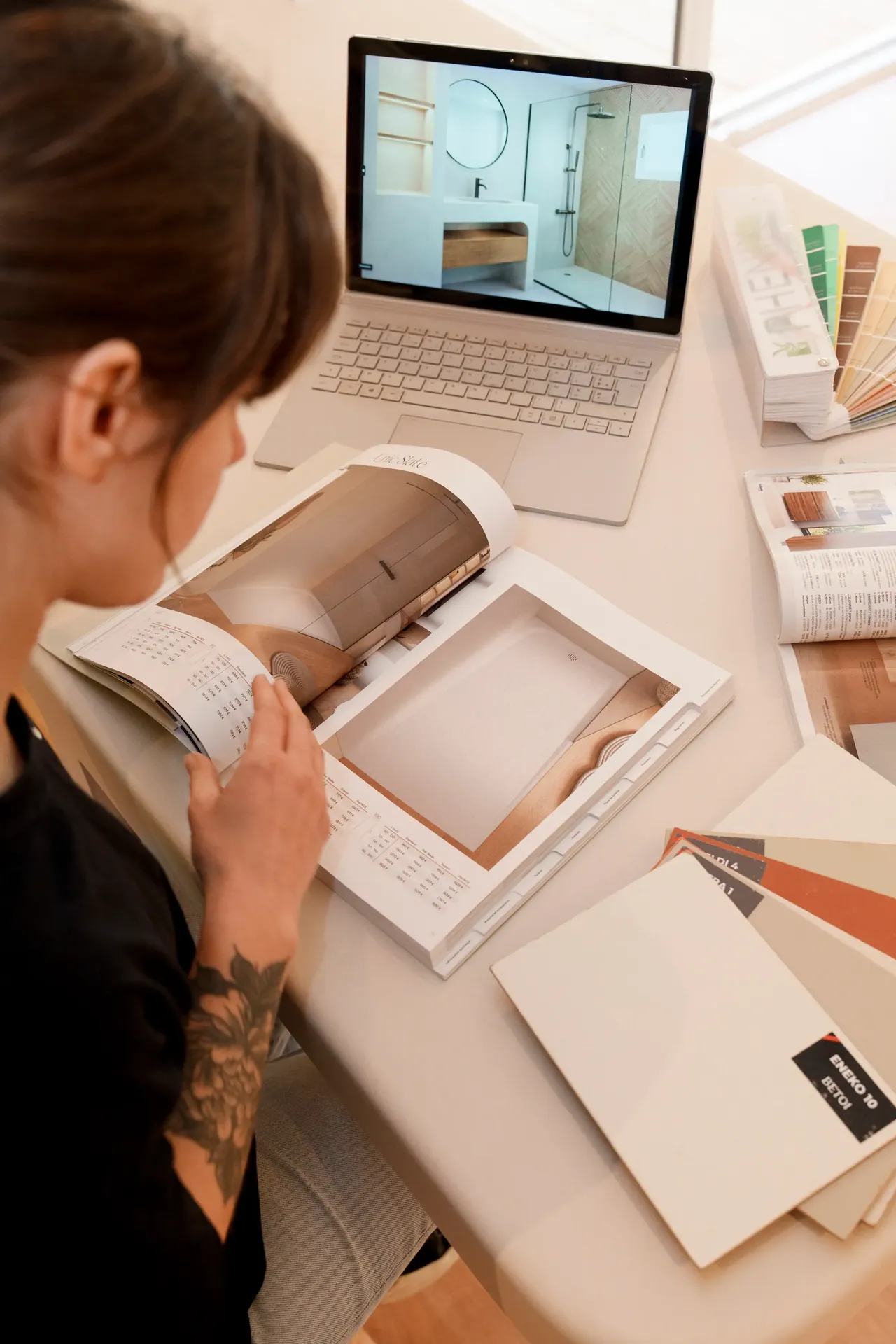 Juliette DOD& en phase de conception — laptop, catalogues et échantillons béton ciré